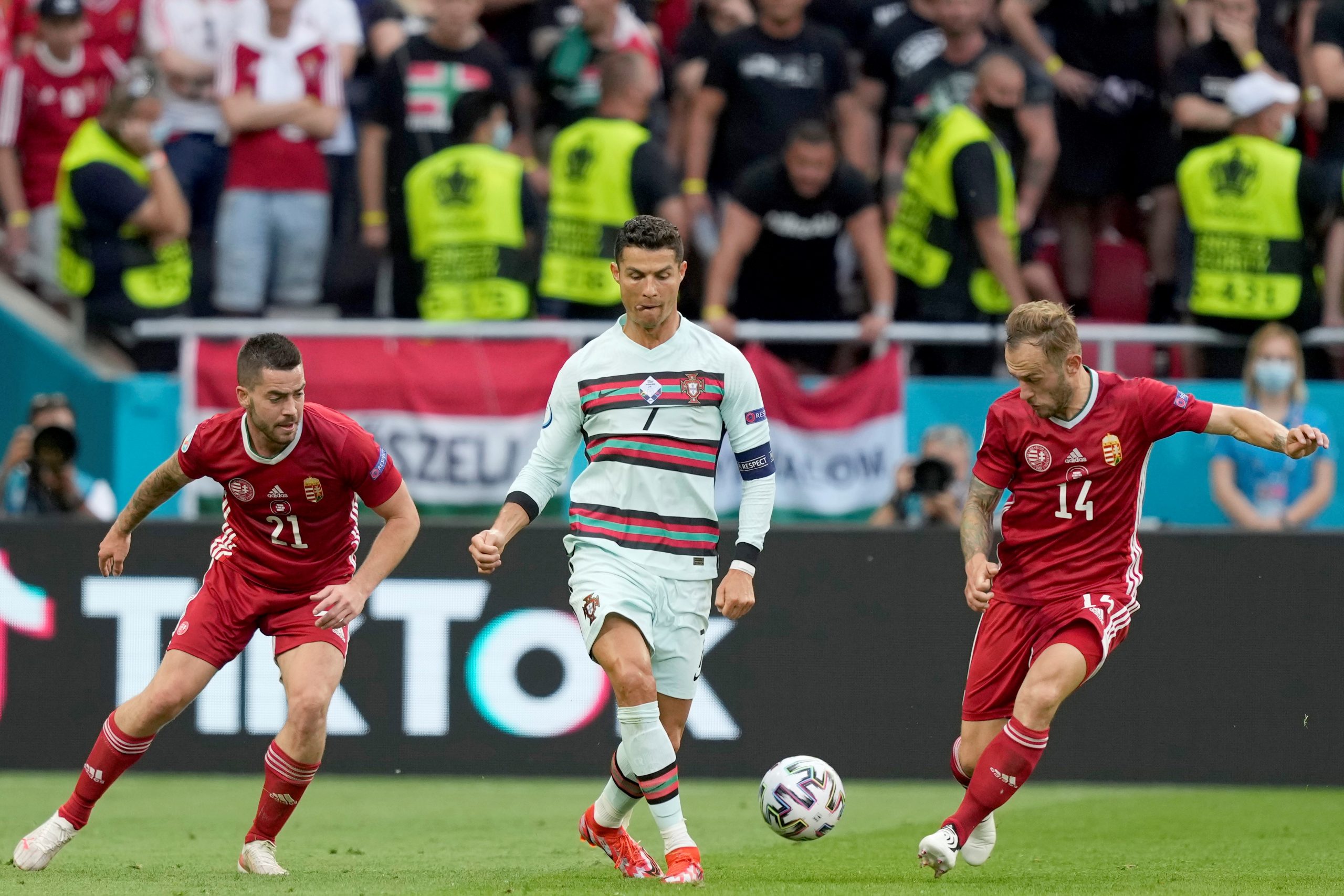 epa09273887 Cristiano Ronaldo (C) of Portugal in action against Endre Botka (L) and Gergo Lovrencsics of Hungary during the UEFA EURO 2020 group F preliminary round soccer match between Hungary and Portugal in Budapest, Hungary, 15 June 2021.  EPA/HUGO DELGADO