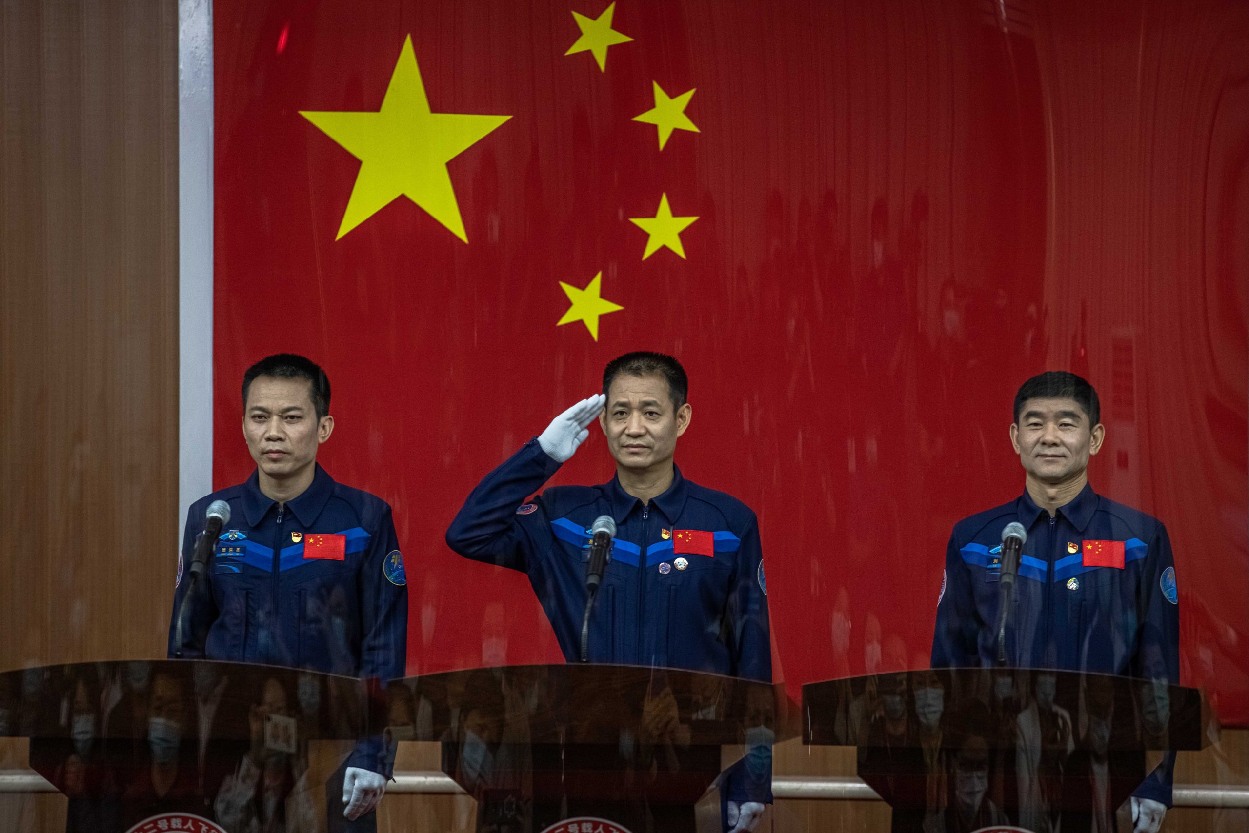 epa09275131 Chinese astronauts (L-R) Tang Hongbo, Nie Haisheng, and Liu Boming participate in a press conference at the Jiuquan Satellite Launch Center, the day before the launching of the Long March-2F carrier rocket, carrying the Shenzhou-12, in northwestern Gansu province, China, 16 June 2021. China will launch the Shenzhou-12 spacecraft carrying three crew members to the orbiting Tianhe core module for a three-month mission on 17 June. It is the first spaceflight in almost five years when China sends humans into space.  EPA/ROMAN PILIPEY