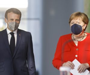 epa09283616 French President Emmanuel Macron (L) and German Chancellor Angela Merkel (R) arrive to give a news statement in Berlin, Germany, 18 June 2021. President Macron and Chancellor Merkel met for bilateral talks.  EPA/AXEL SCHMIDT / POOL