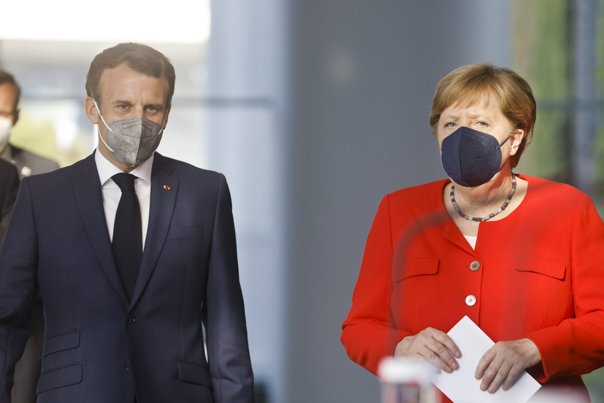 epa09283616 French President Emmanuel Macron (L) and German Chancellor Angela Merkel (R) arrive to give a news statement in Berlin, Germany, 18 June 2021. President Macron and Chancellor Merkel met for bilateral talks.  EPA/AXEL SCHMIDT / POOL