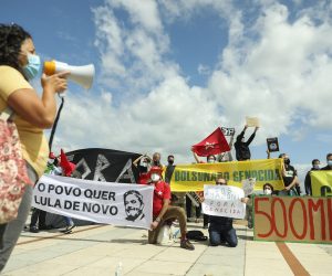 epa09286107 Demonstrators display placards at the 'Bolsonaro Genocide - In defence of life in Brazil' rally, an initiative of the Coletivo Estrela and the Comite de Lutas, in addition to the Brazilian Solidarity group, as part of the 'Bolsonaro Out and Lula President' demonstrations that are also taking place on this day in various parts of Brazil, in Lisbon, Portugal, 19 June 2021.  EPA/MIGUEL A. LOPES