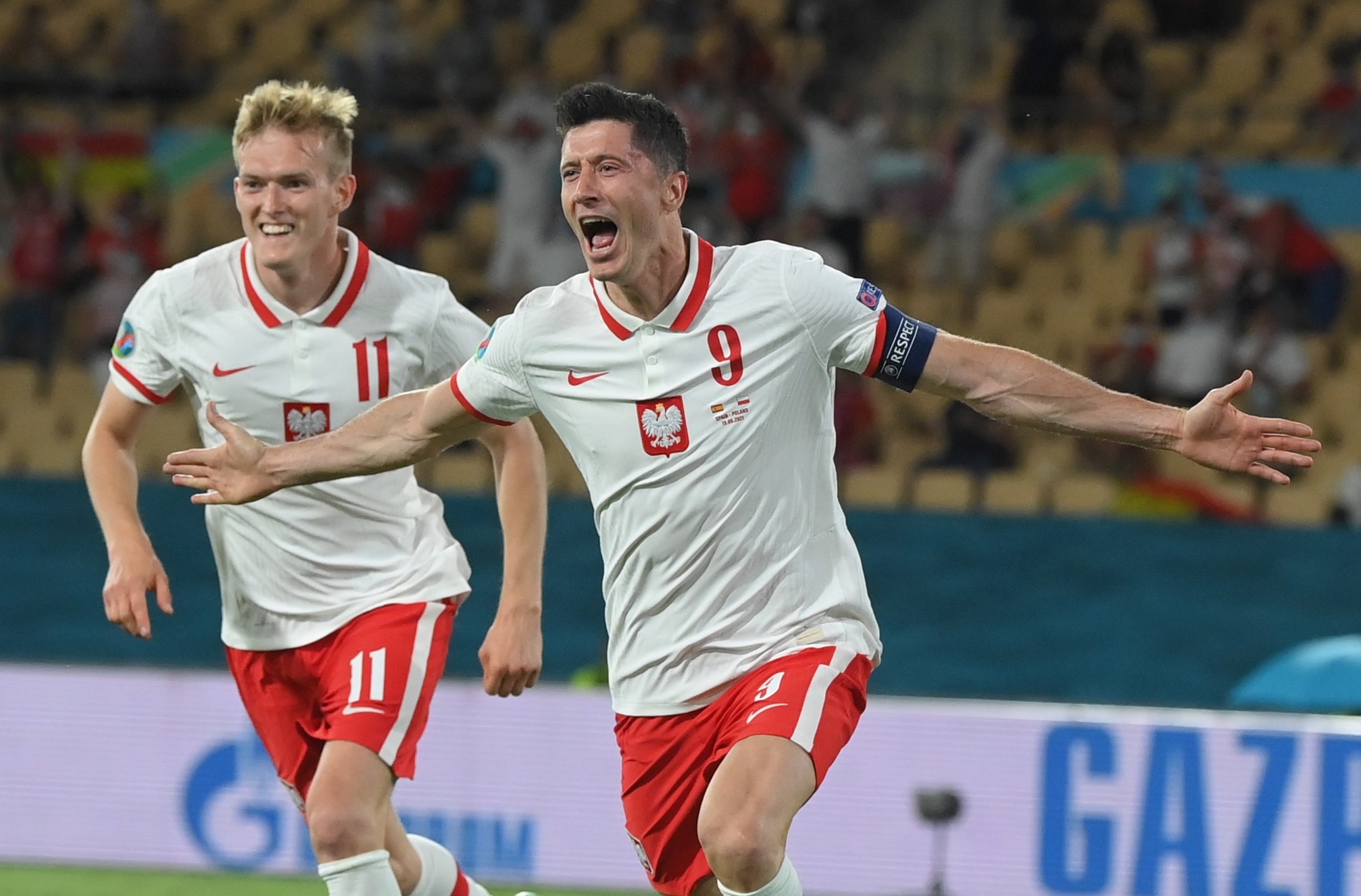 epa09286994 Robert Lewandowski (R) of Poland celebrates with team-mate Karol Swiderski after scoring the 1-1 goal during the UEFA EURO 2020 group E preliminary round soccer match between Spain and Poland in Seville, Spain, 19 June 2021.  EPA/David Ramos / POOL (RESTRICTIONS: For editorial news reporting purposes only. Images must appear as still images and must not emulate match action video footage. Photographs published in online publications shall have an interval of at least 20 seconds between the posting.)