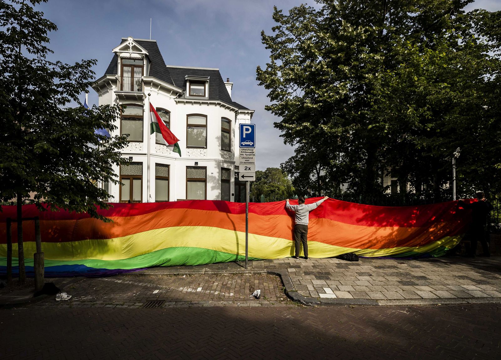 epaselect epa09300445 A meter-long rainbow flag was hung on the fence of the Hungarian embassy in The Hague, The Netherlands, 25 June 2021. That is an action by online soccer platform FC Afkicken, in protest against the anti-gay policy of the Hungarian government. The flag was later removed.  EPA/Remko de Waal