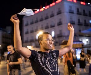 epa09302178 A young man celebrates the end of the mandatory use of facial masks outdoors in Puerta del Sol square in Madrid, Spain, early 26 June 2021. People are allowed to go without facial masks outdoors as long as social distancing is possible.  EPA/RODRIGO JIMENEZ