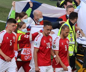 epa09265524 Players of Denmark escort their teammate Christian Eriksen as he is stretchered off the pitch after receiving medical assistanceduring the UEFA EURO 2020 group B preliminary round soccer match between Denmark and Finland in Copenhagen, Denmark, 12 June 2021.  EPA/Wolfgang Rattay / POOL (RESTRICTIONS: For editorial news reporting purposes only. Images must appear as still images and must not emulate match action video footage. Photographs published in online publications shall have an interval of at least 20 seconds between the posting.)