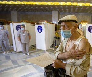 epa09302702 An elderly man leaves a vaccination point after receiving an injection of dose of Russia's Sputnik V (Gam-COVID-Vac) vaccine against COVID-19 in the warderobe zone at the Republican Palace in Chisinau, Moldova, 26 June 2021.  EPA/DUMITRU DORU