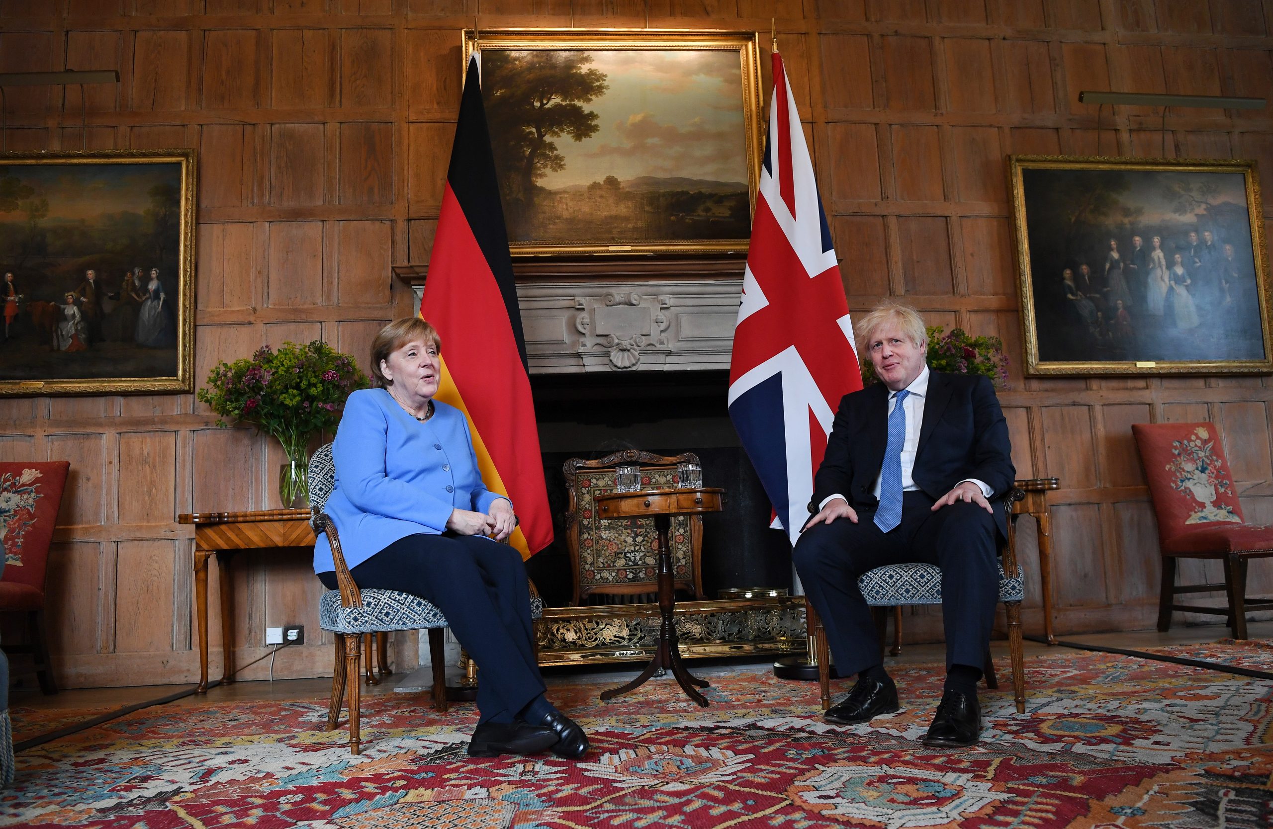 epa09317259 British Prime Minister Boris Johnson (R) with German Chancellor Angela Merkel (L) at the Prime Minster's country residence at Chequers, Buckinghamshire, Britain, 02 July 2021. The two nations have agreed a post Brexit joint declaration on foreign and security policy cooperation. The bilateral agreement is the first to be struck between London and Berlin on foreign and security policy issues.  EPA/ANDY RAIN