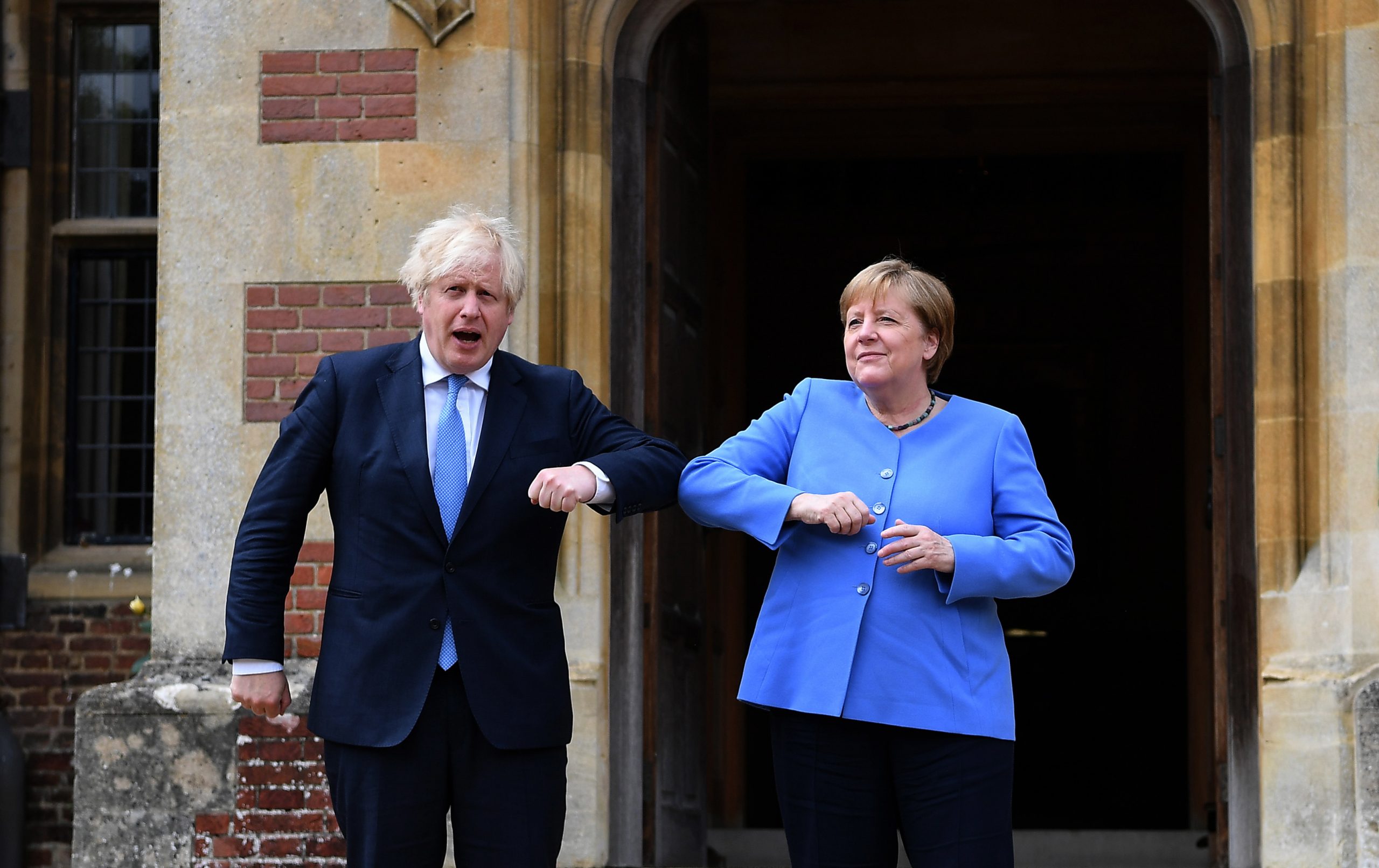 epa09317272 British Prime Minister Boris Johnson (L) and German Chancellor Angela Merkel do an elbow check at the Prime Minster's country residence at Chequers, Buckinghamshire, Britain, 02 July 2021. The two nations have agreed a post Brexit  joint declaration on foreign and security policy cooperation. The bilateral agreement is the first to be struck between London and Berlin on foreign and security policy issues.  EPA/ANDY RAIN / POOL