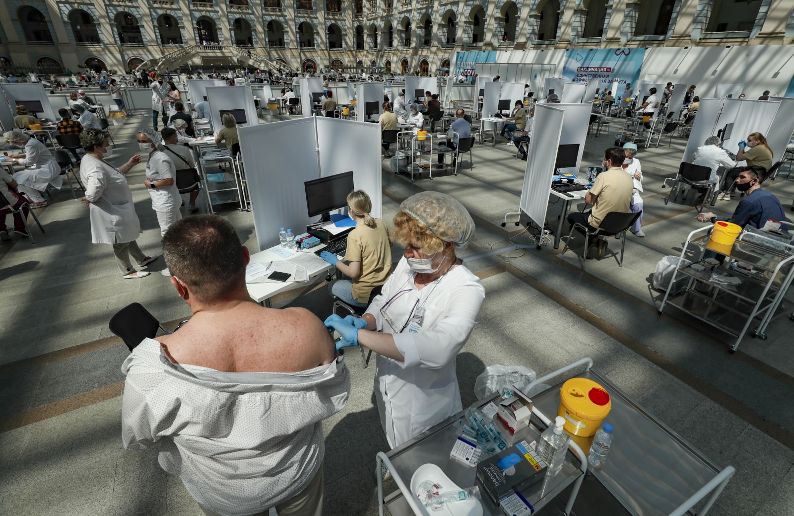 epa09325495 A man receives a shot of Russia's Sputnik V vaccine against COVID-19 disease at a vaccination center in Gostinny Dvor, a huge exhibition place in Moscow in Moscow, Russia, 06 July 2021. Moscow being the epicenter of the new outbreak of the infectious by the new Delta variant. Moscow authorities imposed a ban to serve people without QR-codes confirming vaccination against Covid-19 at public caterings, including people recovering from coronavirus Covid-19 disease within six months before the visit, or negative PCR test taken no earlier than 72 hours before the visit.  EPA/YURI KOCHETKOV