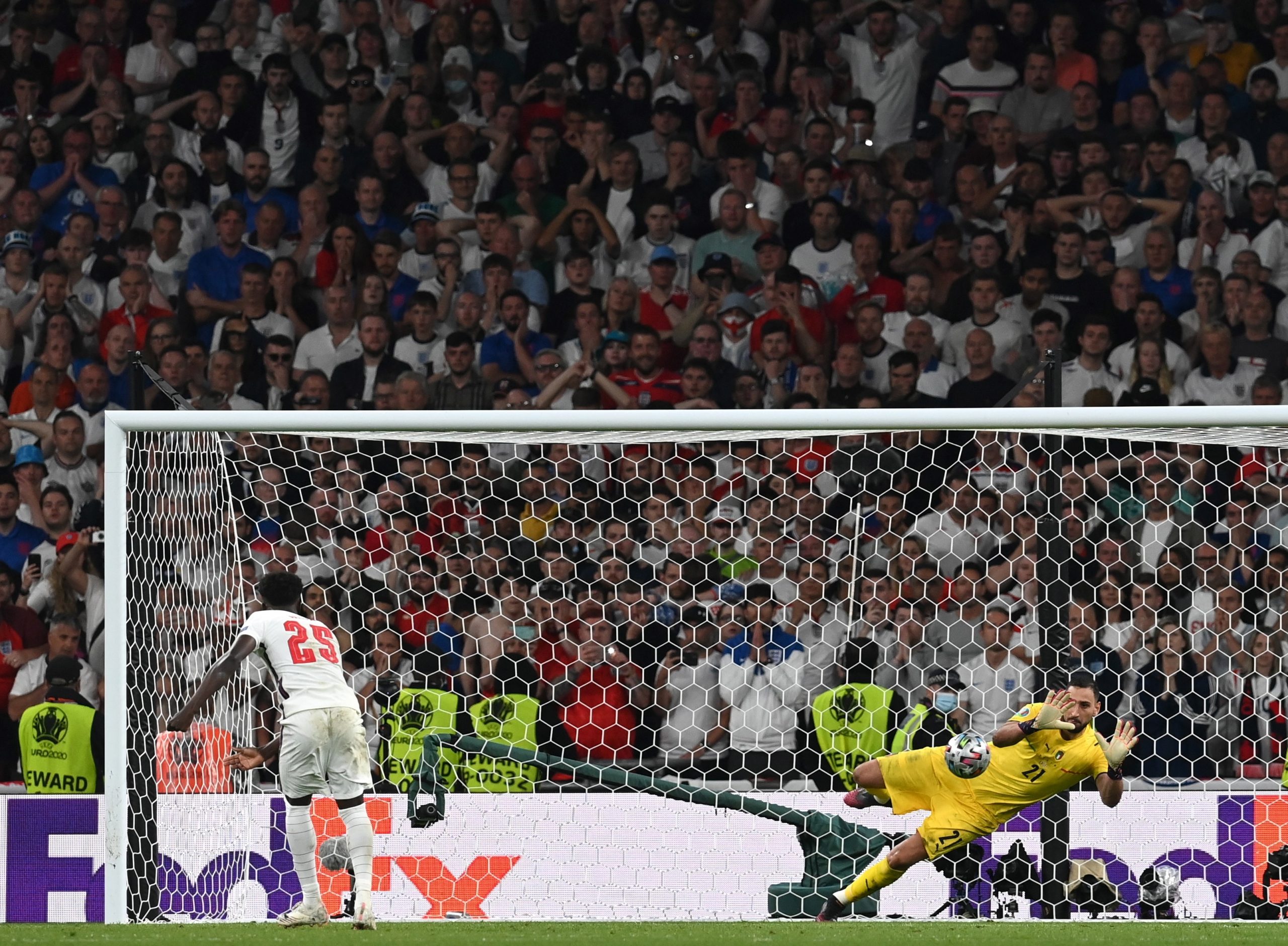 epa09338853 Goalkeeper Gianluigi Donnarumma of Italy saves the penalty of Bukayo Saka of England during the penalty shoot-out of the UEFA EURO 2020 final between Italy and England in London, Britain, 11 July 2021.  EPA/Carl Recine / POOL (RESTRICTIONS: For editorial news reporting purposes only. Images must appear as still images and must not emulate match action video footage. Photographs published in online publications shall have an interval of at least 20 seconds between the posting.)