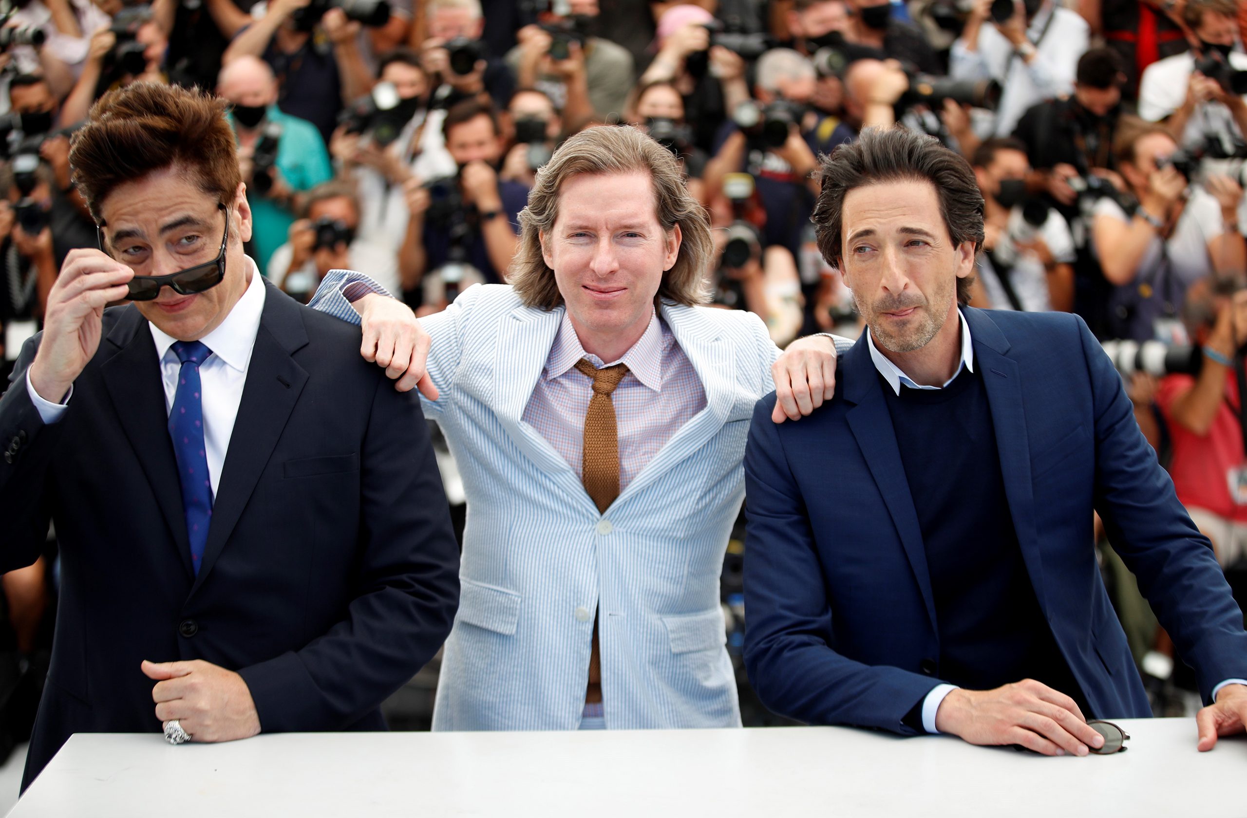 epa09341988 Benicio Del Toro (L), Wes Anderson (C) and Adrien Brody pose during the photocall for 'The French Dispatch' at the 74th annual Cannes Film Festival, in Cannes, France, 13 July 2021. The movie is presented in the Official Competition of the festival which runs from 06 to 17 July.  EPA/SEBASTIEN NOGIER