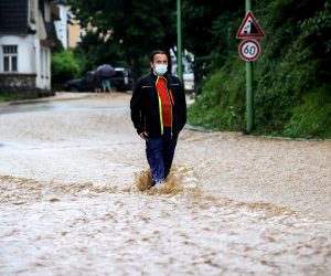 epa09343775 A man walks in the water as heavy rain flooded numerous streets and basements of residential houses in Hagen, Germany, 14 July 2021. Large parts of North Rhine-Westphalia were hit by heavy, continuous rain in the night to Wednesday. According to the German Weather Service (DWD), the rain is not expected to let up until 15 July. The Rhine level has risen significantly in recent days.  EPA/FRIEDEMANN VOGEL