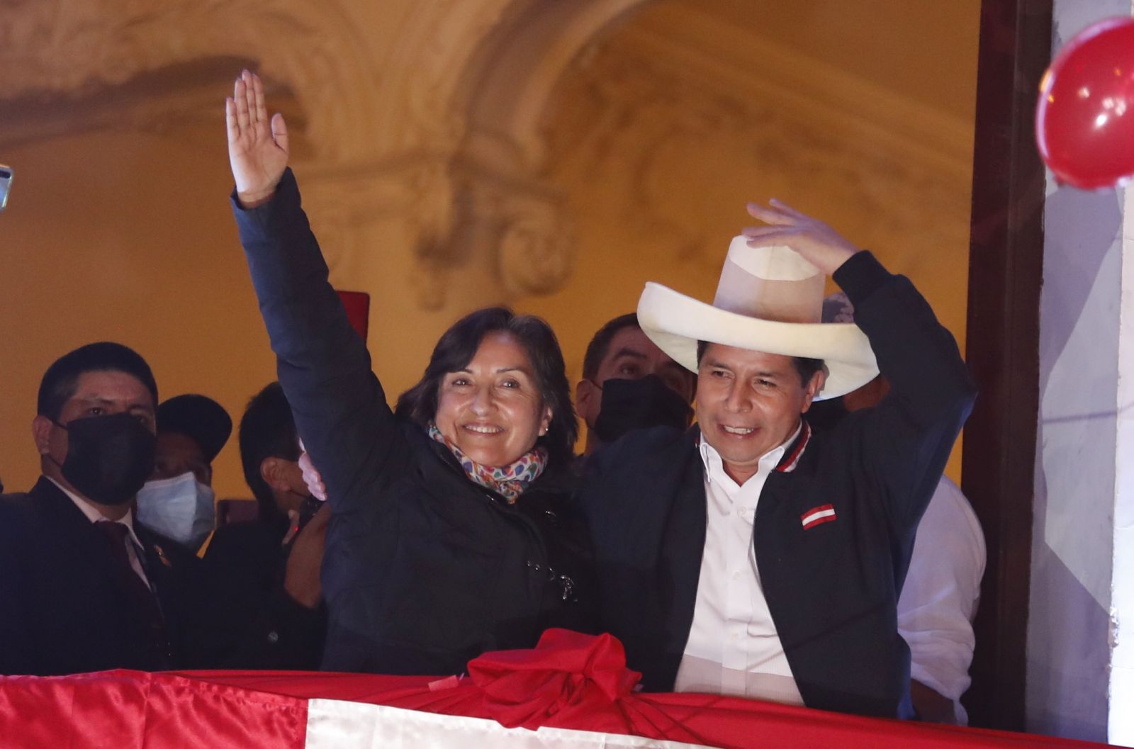 epa09353988 The leftist Pedro Castillo (R), accompanied by his formula to the Vice Presidency Dina Boluarte, greets supporters from a balcony after being proclaimed president-elect of the country, in Lima, Peru 19 July 2021. The official proclamation came this Monday, a month and a half after the elections in which he defeated the right-wing Keiko Fujimori, who delayed his appointment with more than a thousand challenges in which she denounced alleged 'fraud' without reliable evidence. After declaring the latest legal appeals presented by Fujimori unfounded, the National Elections Jury (JNE) endorsed the results of the 06 June vote, where Castillo obtained 50.12% of the valid votes, a narrow victory by just 44,263 votes over Fujimori.  EPA/Paolo Aguilar