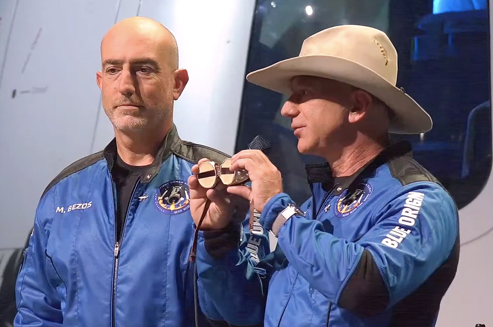 epa09355317 A frame grab from a Blue Origin handout video showing Jeff Bezos (R) and Mark Bezos during a press conference after Blue Origin New Shepard made a trip to space following lift off from Launch Site One, Texas, USA, 20 July 2021.  EPA/BLUE ORIGIN / HANDOUT  HANDOUT EDITORIAL USE ONLY/NO SALES