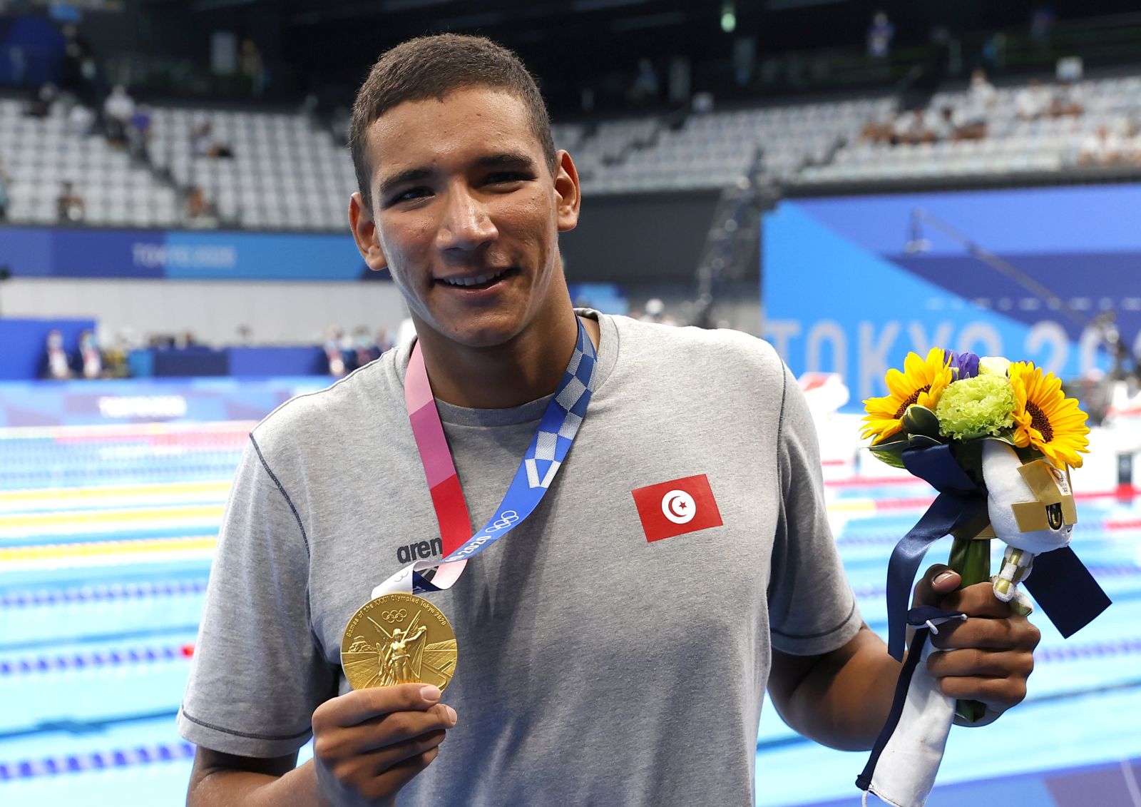 epa09363399 Ahmed Hafnaoui of Tunisia poses with his gold medal after winning the Men's 400m Freestyle final during the Swimming events of the Tokyo 2020 Olympic Games at the Tokyo Aquatics Centre in Tokyo, Japan, 25 July 2021.  EPA/VALDRIN XHEMAJ