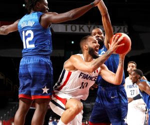 epa09364781 Evan Fournier (C) of France in action against  Jrue Holiday (L) of USA during the 2020 Tokyo Summer Olympics basketball game between France and United States of America, at Saitama Super Arena in Tokyo, Japan, 25 July 2021.  EPA/MICHAEL REYNOLDS