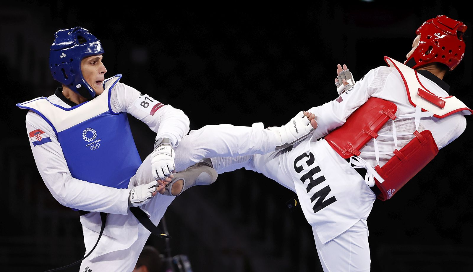 epa09369106 Hongyi Sun of China (red) fights with Ivan Sapina of Croatia in the Men's +80kg quarterfinal during the Taekwondo events of the Tokyo 2020 Olympic Games at the Makuhari Messe convention centre in Chiba, Japan, 27 July 2021.  EPA/RITCHIE B. TONGO