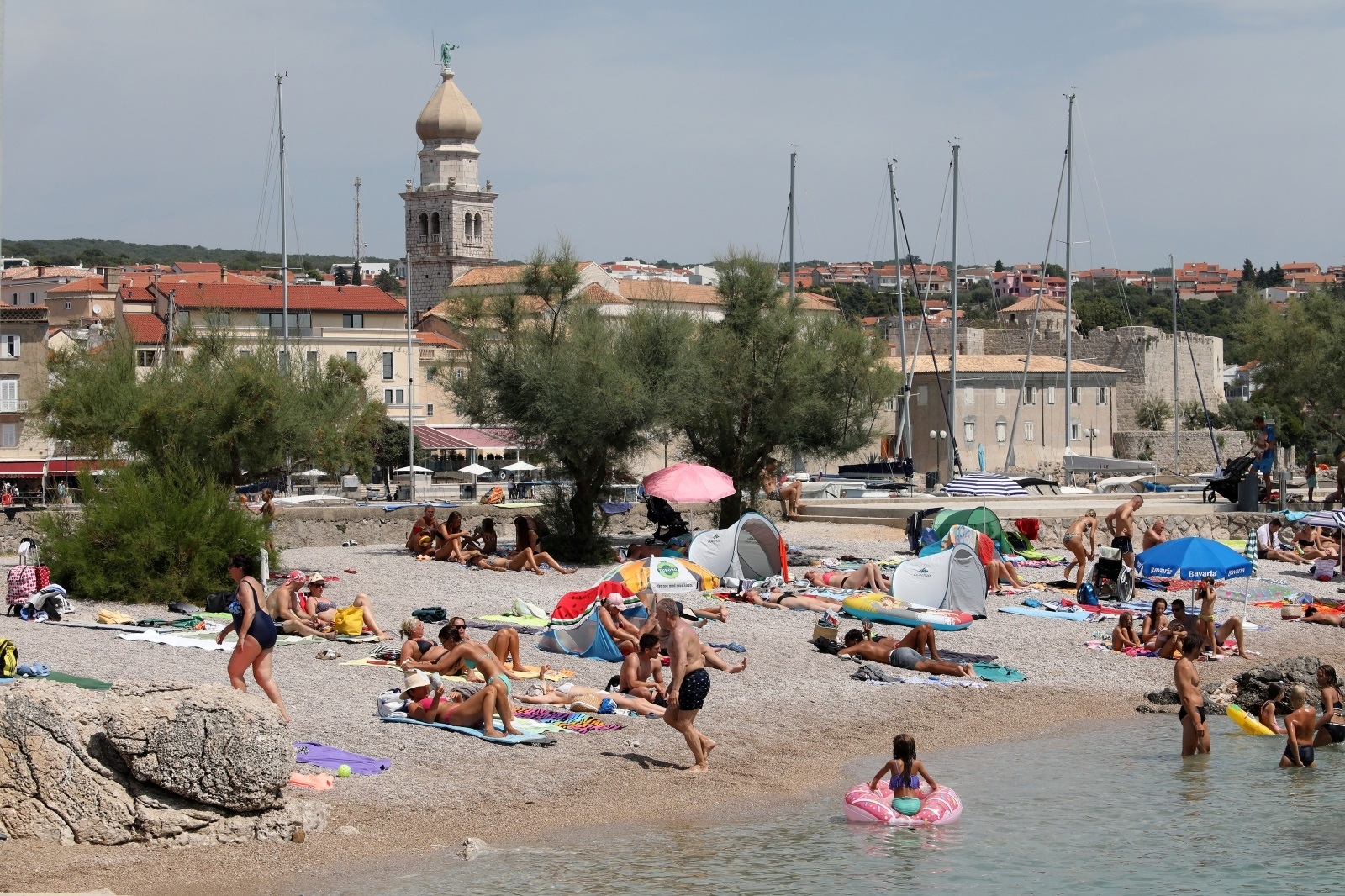 28.07.2021., Krk - Mnogobrojni su turisti spas od vrucine potrazili na plazi Jezevac i lukobranu pred gradom Krkom. Photo: Goran Kovacic/PIXSELL