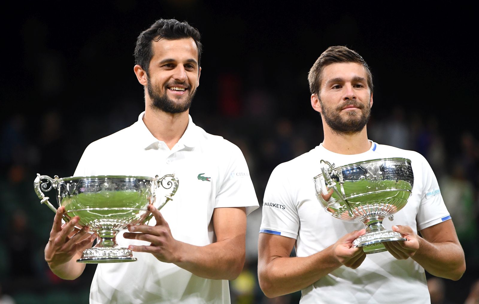epa09336394 Croatian players Mate Pavic (L) and Nikola Mektic (R) pose with their trophies after winning their men's doubles final against Marcel Granollers of Spain and Horacio Zeballos of Argentina at the Wimbledon Championships in Wimbledon, Britain, 10 July 2021.  EPA/NEIL HALL   EDITORIAL USE ONLY