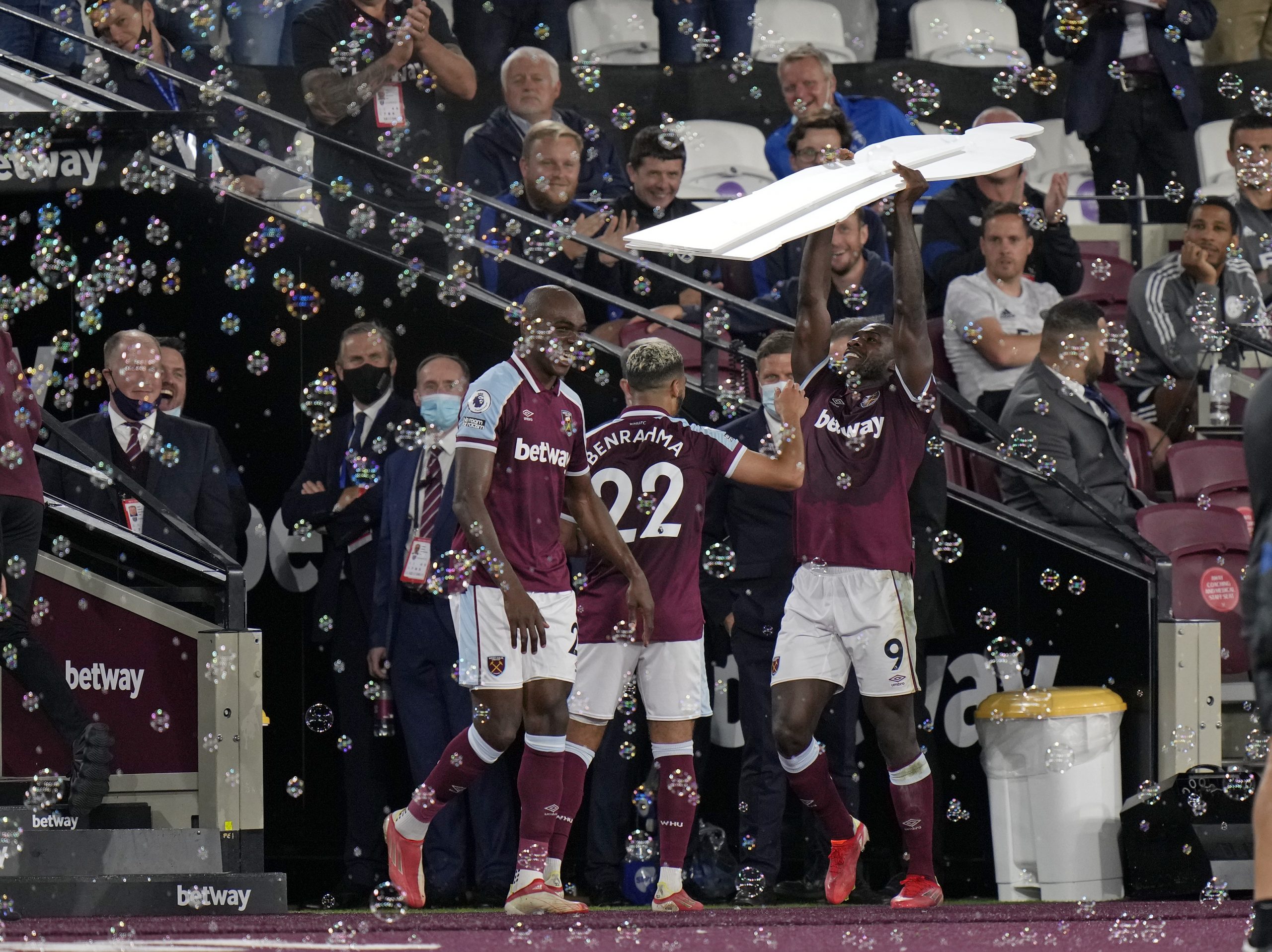 West Ham's Michail Antonio, right, holds aloft a cardboard cutout of himself as he celebrates after scoring his side's third goal during the English Premier League soccer match between West Ham United and Leicester City and at the London Stadium in London, Monday, Aug. 23, 2021. (AP Photo/Alastair Grant)