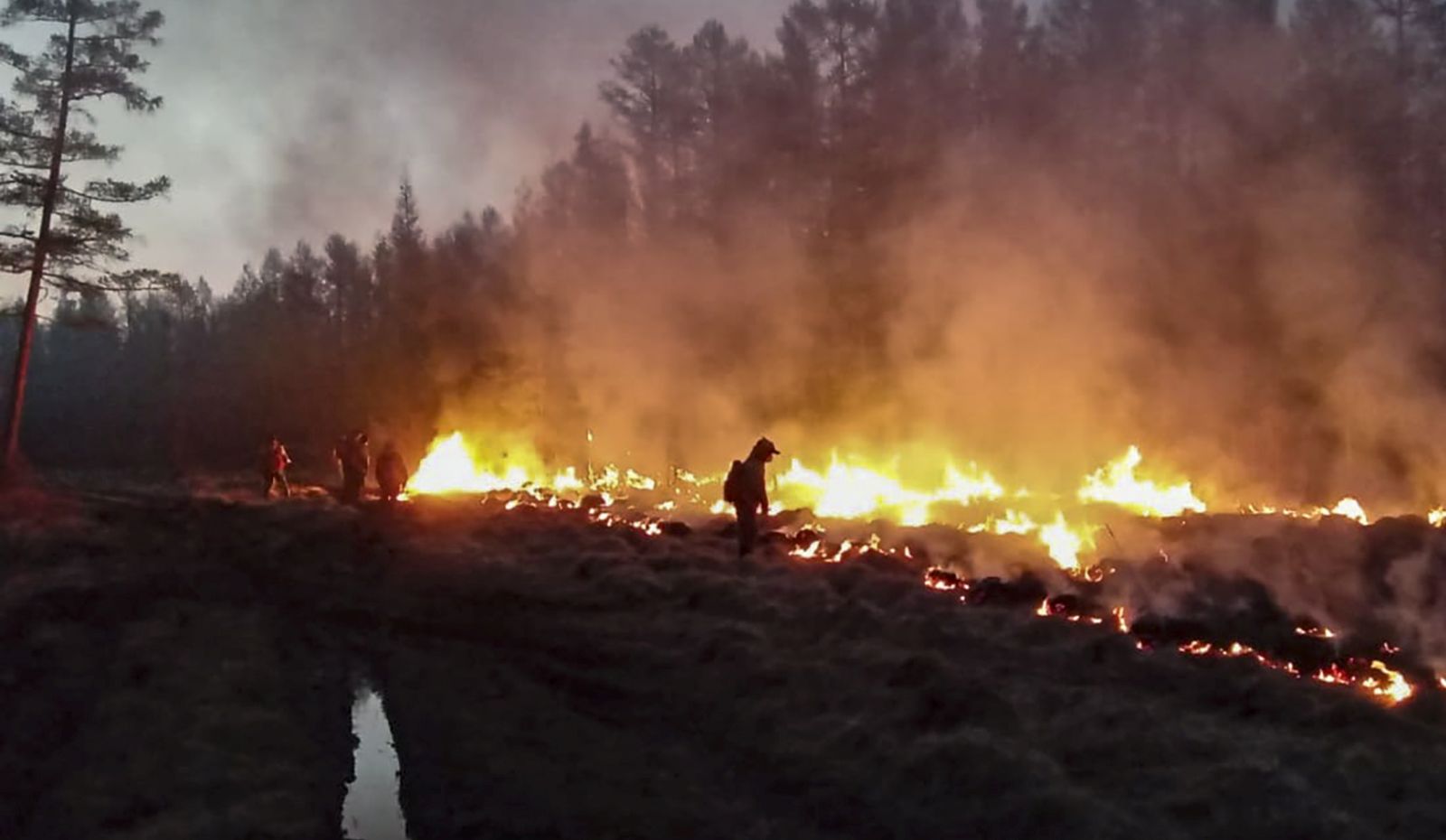 epa09359691 A handout photo made available by the Ministry for Nature Protection of the Sakha Republic (Yakutia) on 23 July 2021, shows fire fighters try to extinguish wildfire in the Republic of Sakha (Yakutia), Russia.  According to the operational data of Russian Emergency ministry, 216 wildfires are active on the territory of the Republic of Sakha (Yakutia). 2,119 people and 297 pieces of equipment were involved in extinguishing forest fires in Yakutia.  EPA/MINISTRY OF NATURE PROTECTION OF YAKUTIA HANDOUT HANDOUT HANDOUT EDITORIAL USE ONLY/NO SALES HANDOUT EDITORIAL USE ONLY/NO SALES