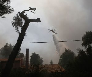 epa09370849 A firefighting helicopter douses a wildfire in the area of Stamata, in north-eastern Athens, Greece, 27 July 2021. Firefighting forces are operating in the area of Stamata, in the Attica region, to contain a wildfire that broke out earlier in the day. Some 22 fire engines with 68 crew members, three teams of firemen on foot, the municipality's water trucks along with four firefighting aircraft, and five water dropping helicopters are currently battling the blaze which is very close to inhabited areas. In the meanwhile, the Civil Protection's emergency number 112 was activated in the wider region of Stamata and Rodopoli informing the citizens to be on alert and follow authorities' instructions.  EPA/YANNIS KOLESIDIS