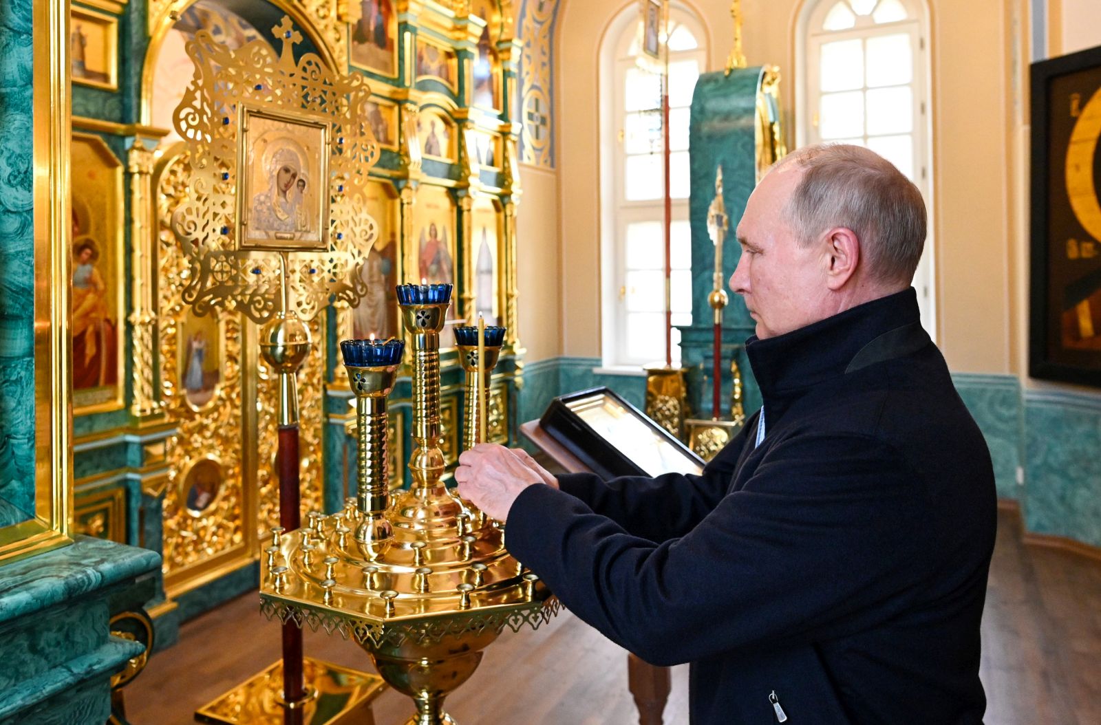 epa09385501 Russian President Vladimir Putin lights a candle visiting the Konevsky Monastery on Konevets Island on Ladoga Lake in Leningrad region, 31 July 2021 (Issued 01 August 2021). The monastery, built at the beginning of the 19th century, was later practically destroyed. In 2016, Vladimir Putin visited Konevets and gave instructions to restore the main temple and skete of the Konevskaya Icon of the Mother of God. To date, the monastery has been restored by the forces and means of Russian oil company 'Rosneft'.  EPA/ALEXEI NIKOLSKY/SPUTNIK/KREMLIN POOL / POOL