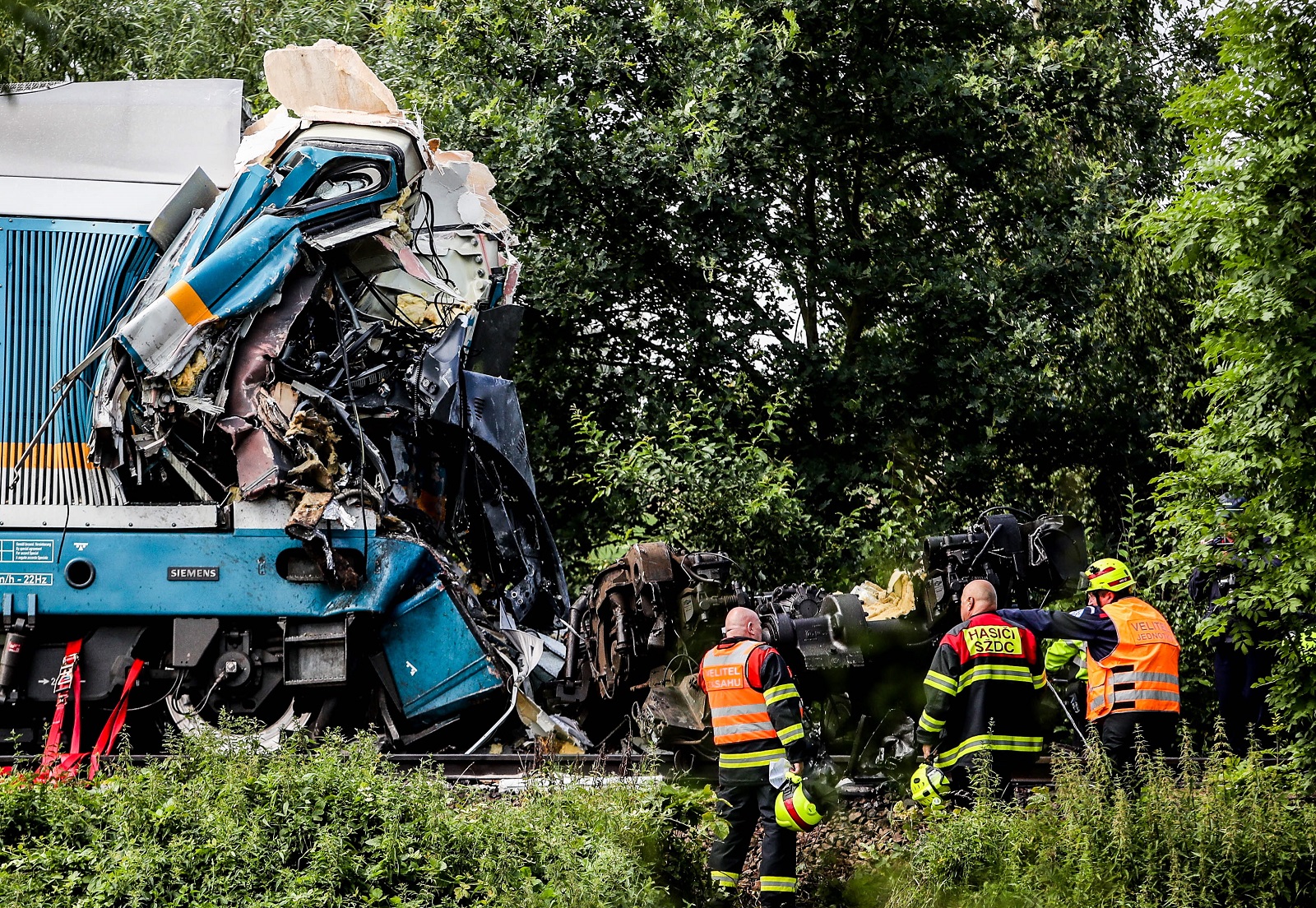 epa09393970 Rescuers at the scene of a train crash near the city of Domazlice, Czech Republic, 04 August 2021. According to state media citing firefighters, at least three people died and 38 were injured when a train coming from Munich and a local train collided.  EPA/MARTIN DIVISEK