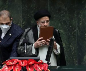 epa09398424 Iranian President Ebrahim Raisi (R) kisses the holy Koran after being sworn-in for his first four-year term of presidency at the parliament in Tehran, Iran, 05 August 2021.  Iran's new president Ebrahim Raisi was sworn in on 05 August before parliament in Tehran in a ceremony that foreigners attended for the second time since the Islamic Revolution in 1979. Raise is to present his cabinet to the 290-seat parliament for approval in the next week.  EPA/ABEDIN TAHERKENAREH