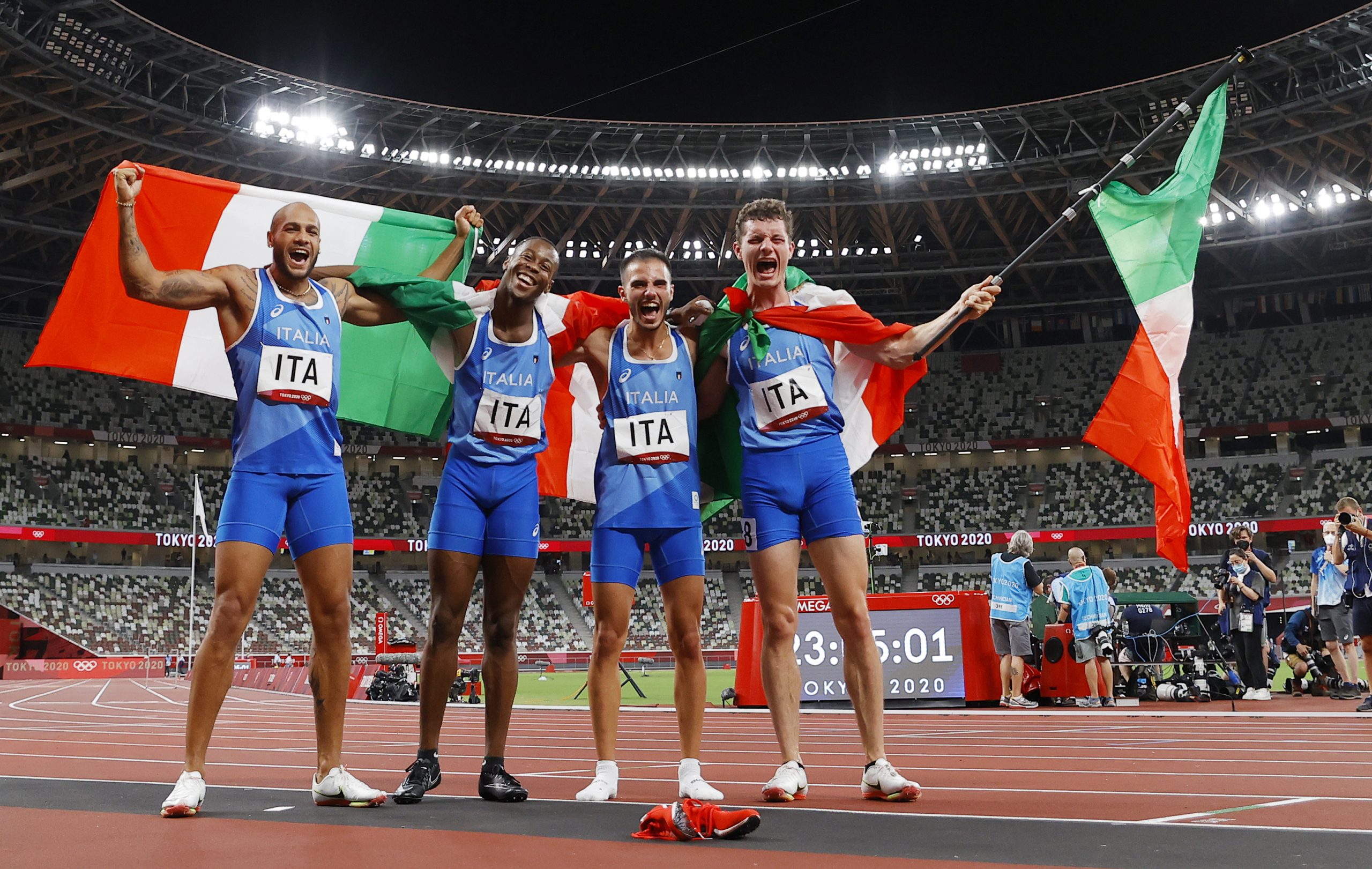 epa09401576 Lamont Marcell Jacobs, Eseosa Fostine Desalu, Lorenzo Patta and Filippo Tortu of Italy celebrate after winning the Men's 4x100m Relay final of the Athletics events of the Tokyo 2020 Olympic Games at the Olympic Stadium in Tokyo, Japan, 06 August 2021.  EPA/VALDRIN XHEMAJ