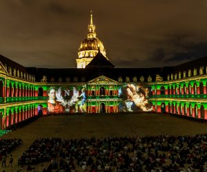 epa09408922 Spectators look at the sound and light show 'La Nuit aux Invalides,  Napoleon The Flight of the Eagle ' displayed on the walls of the Invalides National Hotel, in Paris, France, 10 August 2021, part of the cultural event of the Napoleon's year dedicated to the French emperor Napoleon Bonaparte. The outdoor show , created by Bruno Seillier, runs from 07 July to 26 August 2021.  EPA/CHRISTOPHE PETIT TESSON