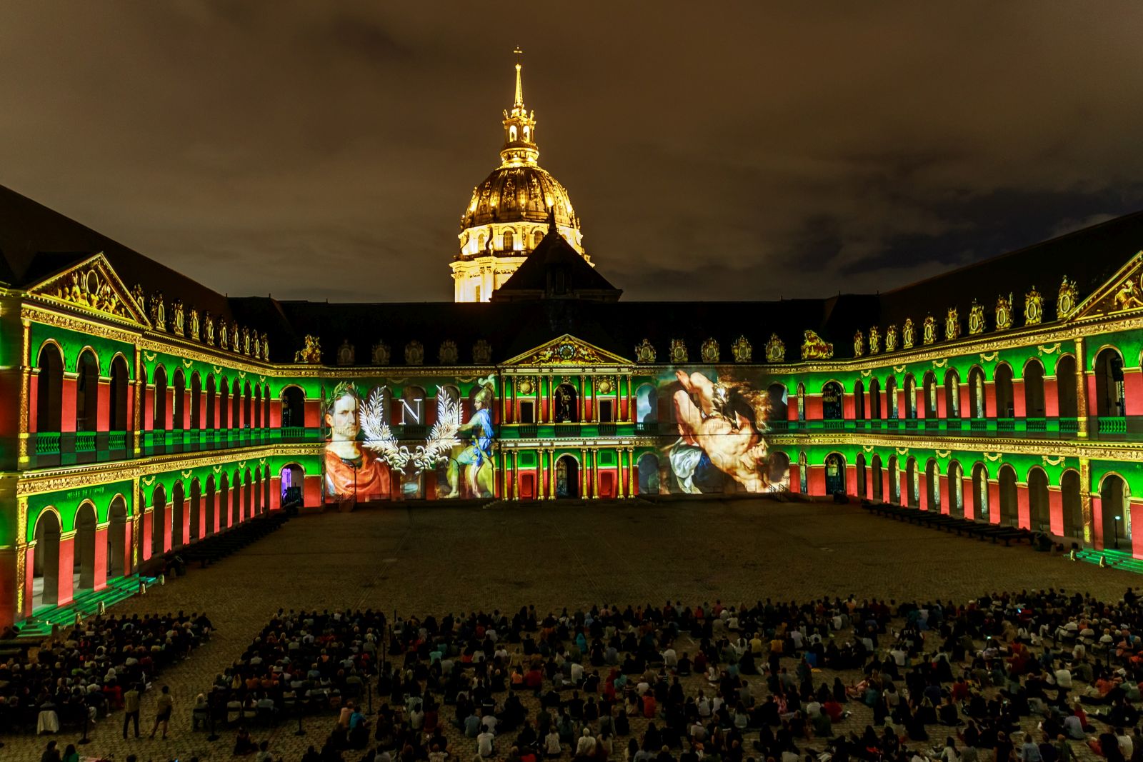 epa09408922 Spectators look at the sound and light show 'La Nuit aux Invalides,  Napoleon The Flight of the Eagle ' displayed on the walls of the Invalides National Hotel, in Paris, France, 10 August 2021, part of the cultural event of the Napoleon's year dedicated to the French emperor Napoleon Bonaparte. The outdoor show , created by Bruno Seillier, runs from 07 July to 26 August 2021.  EPA/CHRISTOPHE PETIT TESSON