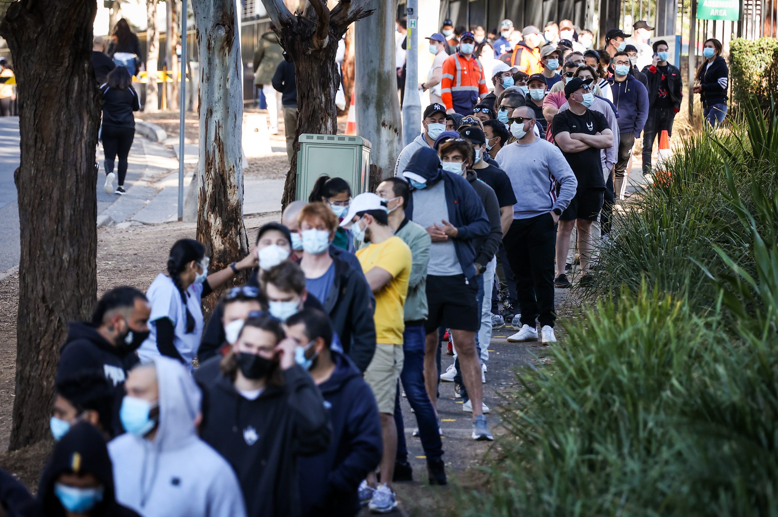 epa09414507 Tradesmen and women stand in a line wearing face masks as they wait to be vaccinated at the Sydney Olympic Park Vaccination Centre at Homebush in Sydney, New South Wales, Australia, 15 August 2021. Greater Sydney and surrounding regions are in lockdown until at least 28 August and the New South Wales Hunter will be locked down for a week as health authorities battle to contain an outbreak of the virulent Delta strain.  EPA/DAVID GRAY AUSTRALIA AND NEW ZEALAND OUT