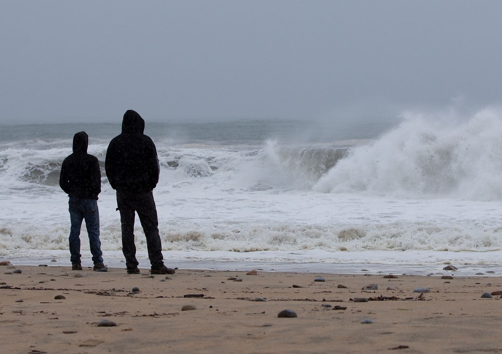 epa09424725 Onlookers watch the waves churned up by Tropical Storm Henri at Misquamicut Beach n Westerly, Rhode Island, USA, 22 August 2021. Tropical Storm Henri is expected to make landfall near the Connecticut and Rhode Island boarders later in the day.  EPA/CJ GUNTHER