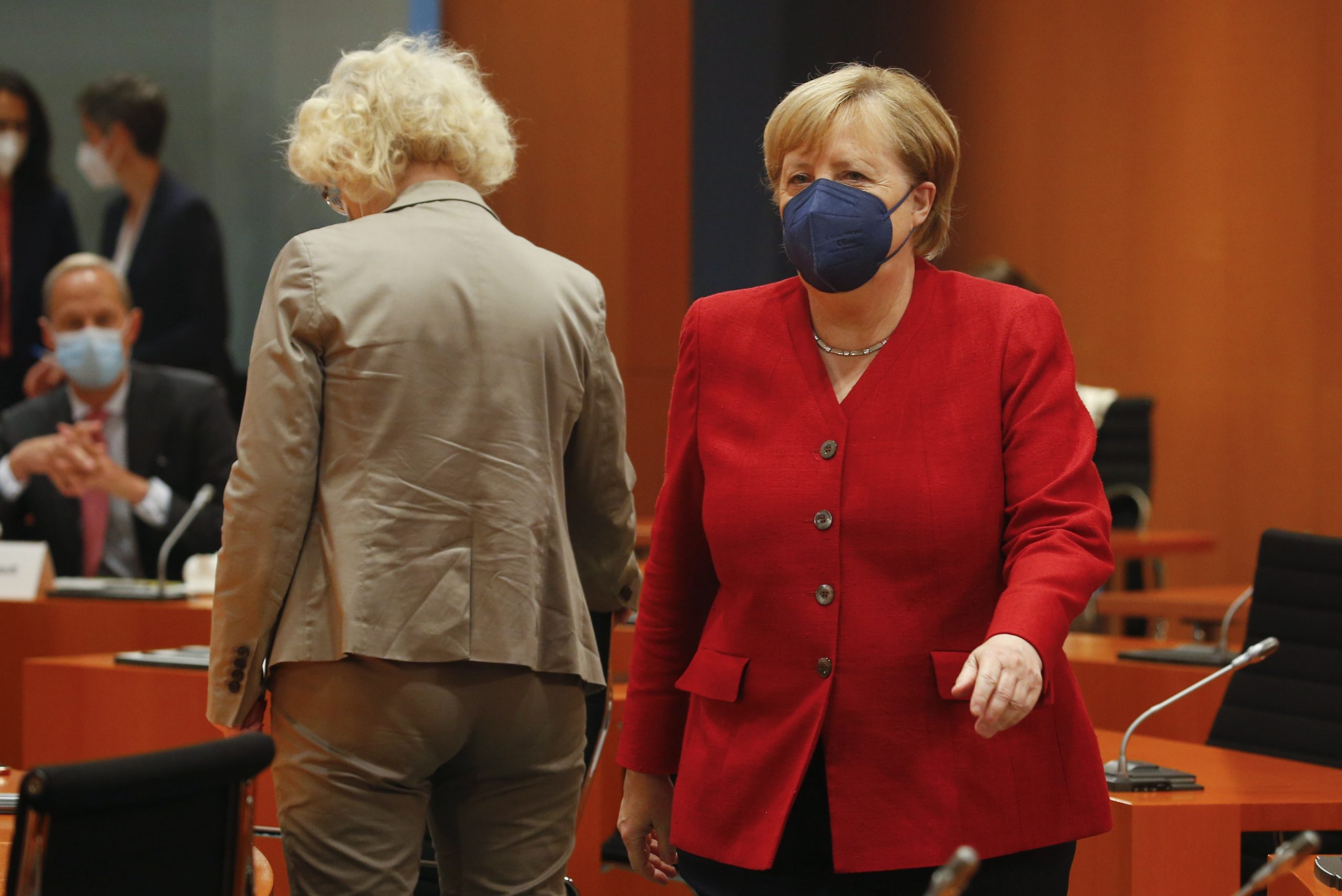 epa09428474 German Chancellor Angela Merkel (R) walks as she attends the weekly German cabinet meeting at the Chancellery in Berlin, Germany, 25 August 2021.  EPA/MICHELE TANTUSSI / POOL