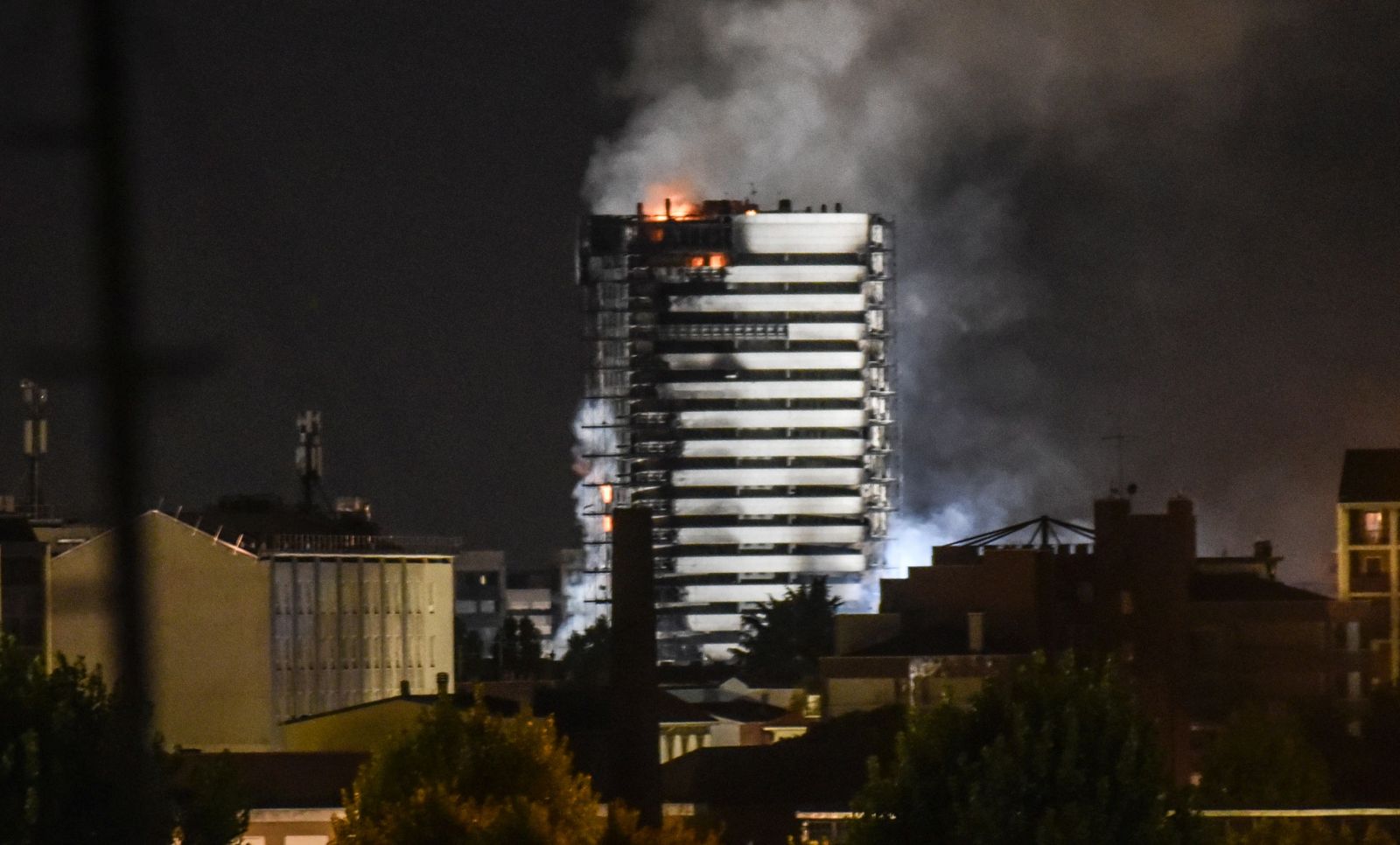 epa09436471 Smoke billows from the ‘Torre del Moro’ a 15-storey luxury building  that caught fire overnight, in Milan, Italy 30 August 2021.  EPA/Matteo Corner