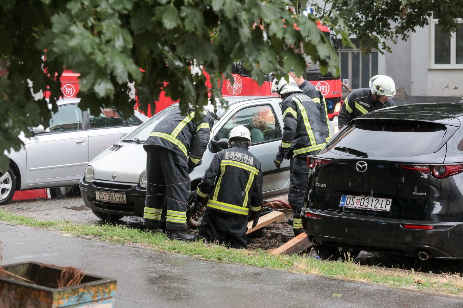 17.07.2021., Osijek - Za vrijeme oluje vatrogasci su izvlacili automobil pod kojim se otvorila rupa dok je stajao na parkiralistu. Photo: Dubravka Petric/PIXSELL
