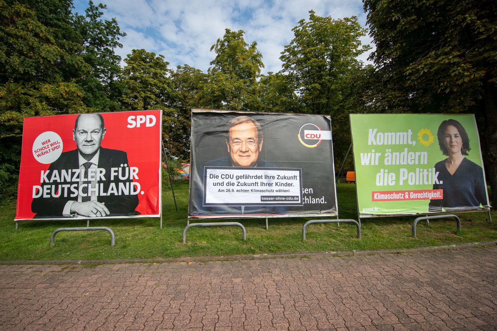 epa09473026 Large election placards of the three leading candidates in the German federal elections (L-R) Olaf Scholz of the Social Democratic Party (SPD), Armin Laschet of the Christian Democratic Union (CDU) and Annalena Baerbock of the Green Party (Buendnis 90/Die Gruenen) in Frankfurt am Main, Germany, 17 September 2021. An anti-CDU sticker was posted on the placard showing Laschet. Germany will hold general elections oon 26 September 2021.  EPA/Constantin Zinn