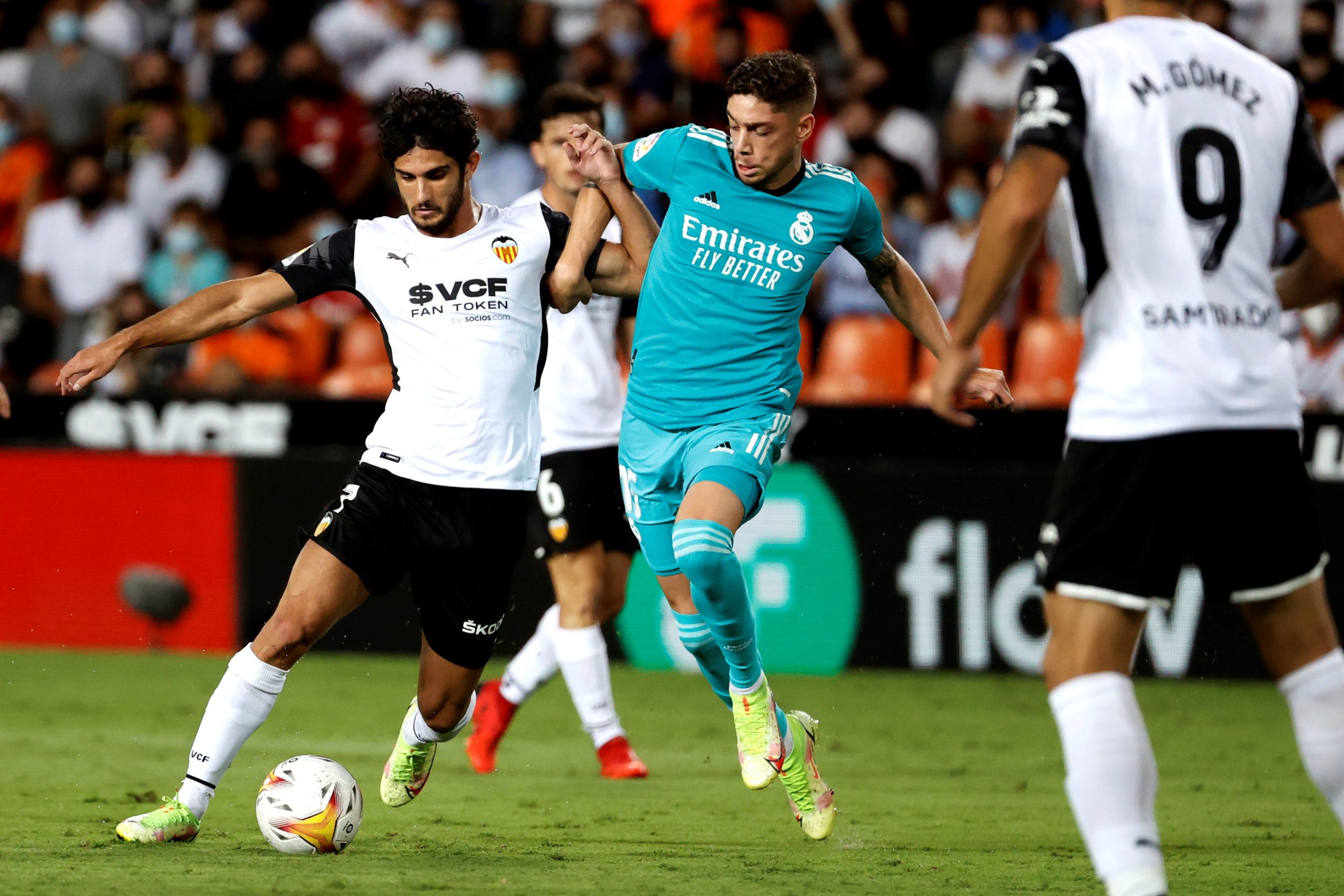 epa09477136 Valencia's striker Gonçalo Guedes (L) vies for the ball with Real Madrid's midfielder Federico Valverde (C) during the Spanish LaLiga soccer match between Valencia CF and Real Madrid held at Mestalla stadium in Valencia, eastern Spain, 19 September 2021.  EPA/Kai Forsterling