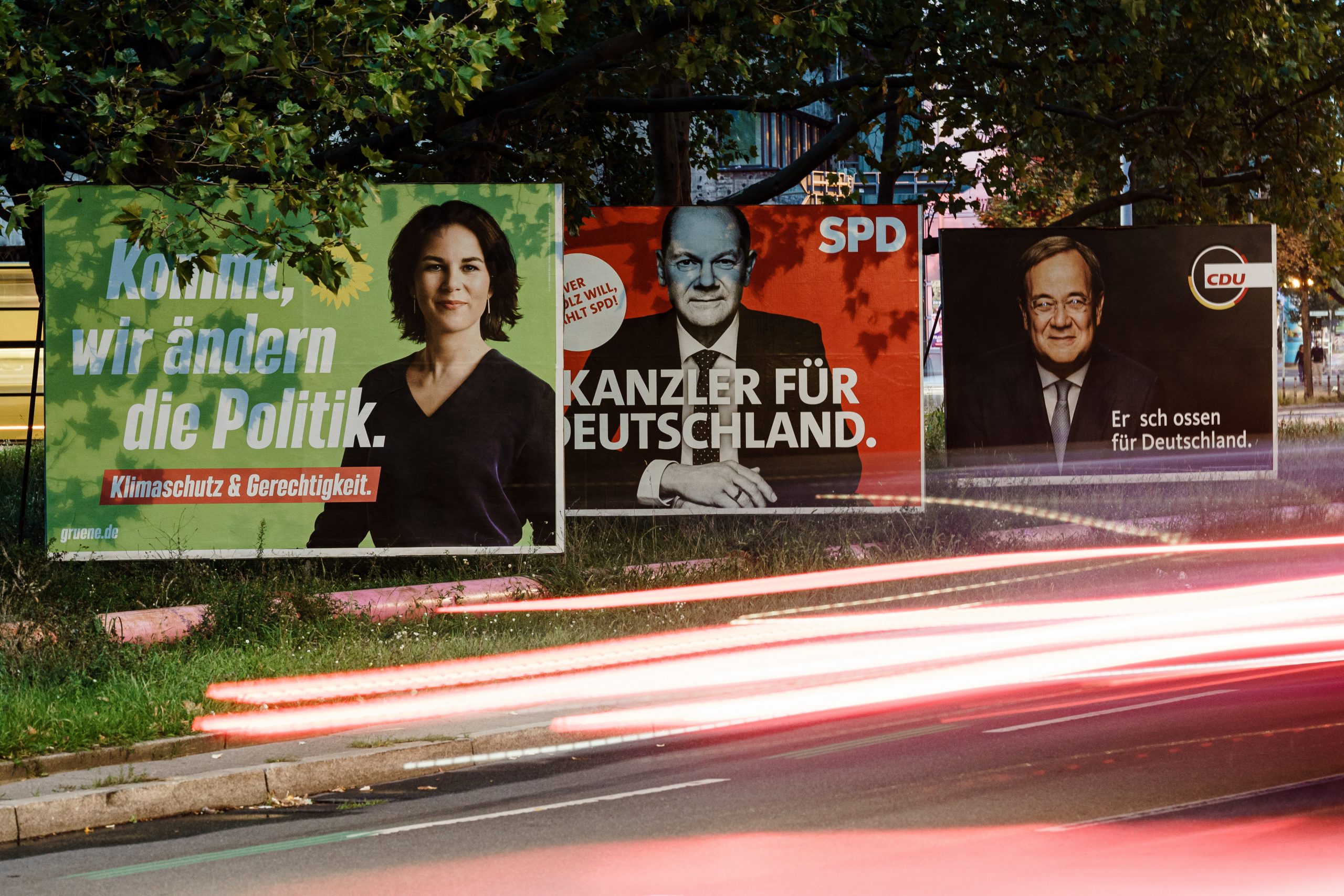 epa09488198 Campaigning posters of the Green party (L), the Social Democrats (C) and the Christian Democratic Union (R) show the top candidates Annalena Baerbock (L), Olaf Scholz (C) and Armin Laschet (R) in Berlin, Germany, 25 September 2021. German federal elections take place on 26 September 2021.  EPA/CLEMENS BILAN