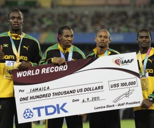 From left, Jamaica's Usain Bolt, Yohan Blake, Michael Frater and Nesta Carter pose on the podium after receiving their gold medals and a giant replica cheque for their new world record in the Men's 4x100 Relay at the World Athletics Championships in Daegu, South Korea, Sunday, Sept. 4, 2011. (AP Photo/Martin Meissner) (AP Photo/Martin Meissner)