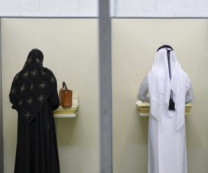 epa09501516 A Qatari woman (L) and man (R) fill their ballots at a polling station in Doha, Qatar, 02 October 2021. Qatar is holding its first legislative elections on 02 October, to elect 30 of the 45 members of the Consultative Assembly (or Shura Council), a legislative body that was previously appointed by the emir as an advisory committee. As per the country's constitution, the remaining 15 members will be appointed by the emir.  EPA/NOUSHAD THEKKAYIL