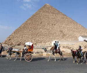 epa09502835 People ride camels past the pyramids in Giza, Egypt, 02 October 2021  EPA/KHALED ELFIQI