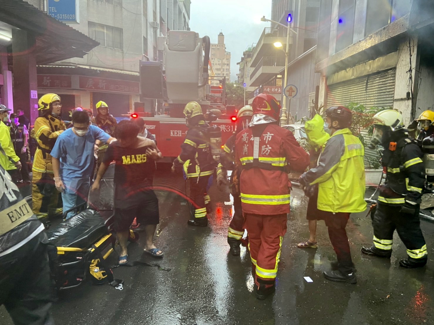 epa09522838 A handout photo made available by Kaohsiung fire bureau shows firefighters and rescuers assisting survivors after a fire on a commercial and residential building in Kaohsiung city, southern Taiwan, 14 October 2021. At least seven persons are dead and several injured after the commercial and residential building fire.  EPA/KAOHSIUNG FIRE BUREAU HANDOUT  HANDOUT EDITORIAL USE ONLY/NO SALES