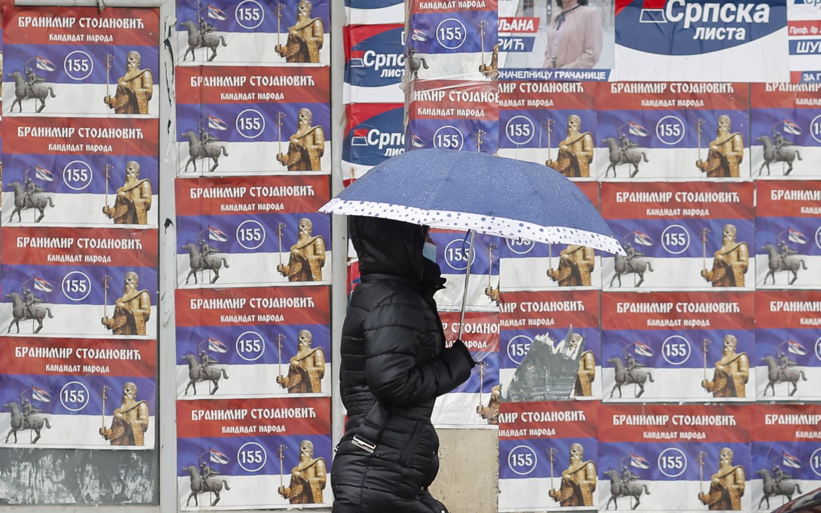 epa09525979 A woman walks in front of the electoral posters in Gracanica, Kosovo, 15 October 2021. Citizens of Kosovo will vote on their local elections on 17 October 2021.  EPA/VALDRIN XHEMAJ