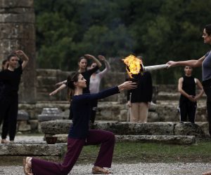 epa09528355 Greek actress Xanthi Georgiou (R), playing the role of High Priestess, lights the flame during the rehearsal of the Olympic flame lighting ceremony for the Beijing 2022 Winter Olympics, at the Ancient Olympia site, in southern Greece, 17 October 2021.  EPA/YANNIS KOLESIDIS