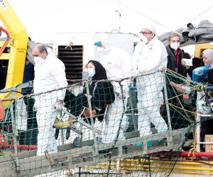 epa09540815 Italian authorities in protective suits help a migrant (C) disembark from the ship Sea-Watch 3 in Pozzallo, near Ragusa, Sicily Island, southern Italy, 23 October 2021. The Sea Watch 3 ship arrived in Pozzallo with 406 migrants rescued in various operations in the Mediterranean. Italian authorities allowed the ship of the German NGO safe harbor and the disembarkment of the migrants.  EPA/FRANCESCO RUTA