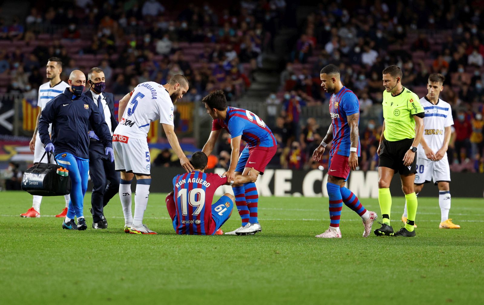 epa09555158 FC Barcelona's striker Sergio 'Kun' Aguero (C) reacts after suffering an injury during the Spanish LaLiga soccer match between FC Barcelona and Deportivo Alaves held at Camp Nou stadium in Barcelona, Spain, 30 October 2021.  EPA/Toni Albir