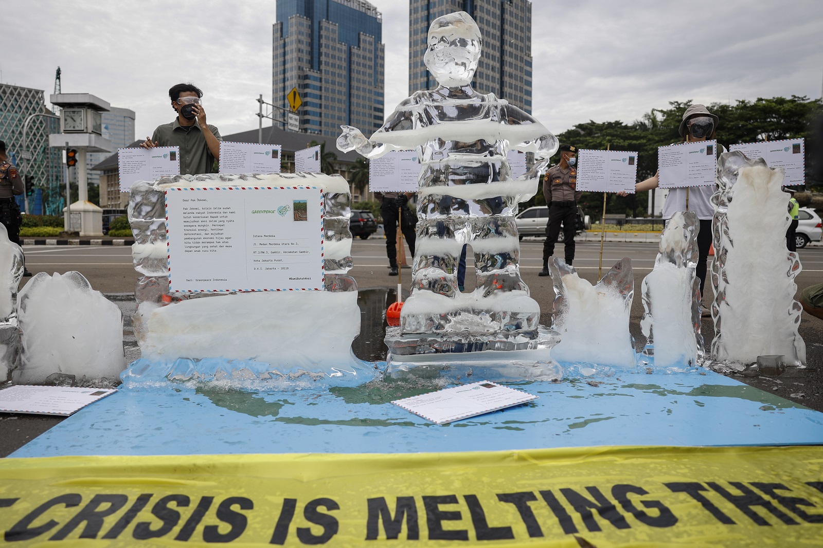 epa09573409 A melting ice statue of a kid is seen as activists hold placards during a climate change protest in Jakarta, Indonesia, 10 November 2021. A number of environmental activists from environmental organisation Greenpeace staged a protest demanding the government to accelerate actions on fighting the climate change and reducing the greenhouse emissions. Environmental activists and leaders are gathered in Glasgow at the 2021 United Nations Climate Change Conference (COP26) running from 31 October to 12 November 2021.  EPA/MAST IRHAM