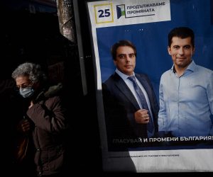 epa09573937 A women passes next to an election poster of the leaders of the party 'We continue the change' Kiril Petkov (R) and Asen Wassilv (L) in Sofia, Bulgaria, 10 November 2021. Bulgaria will hold its Parliamentary and Presidential Elections on 14 November 2021.  EPA/VASSIL DONEV